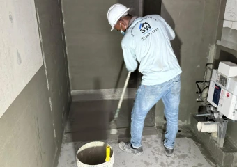 A waterproofing specialist coating the floor of a wet area or bathroom to provide long-term protection against internal moisture.